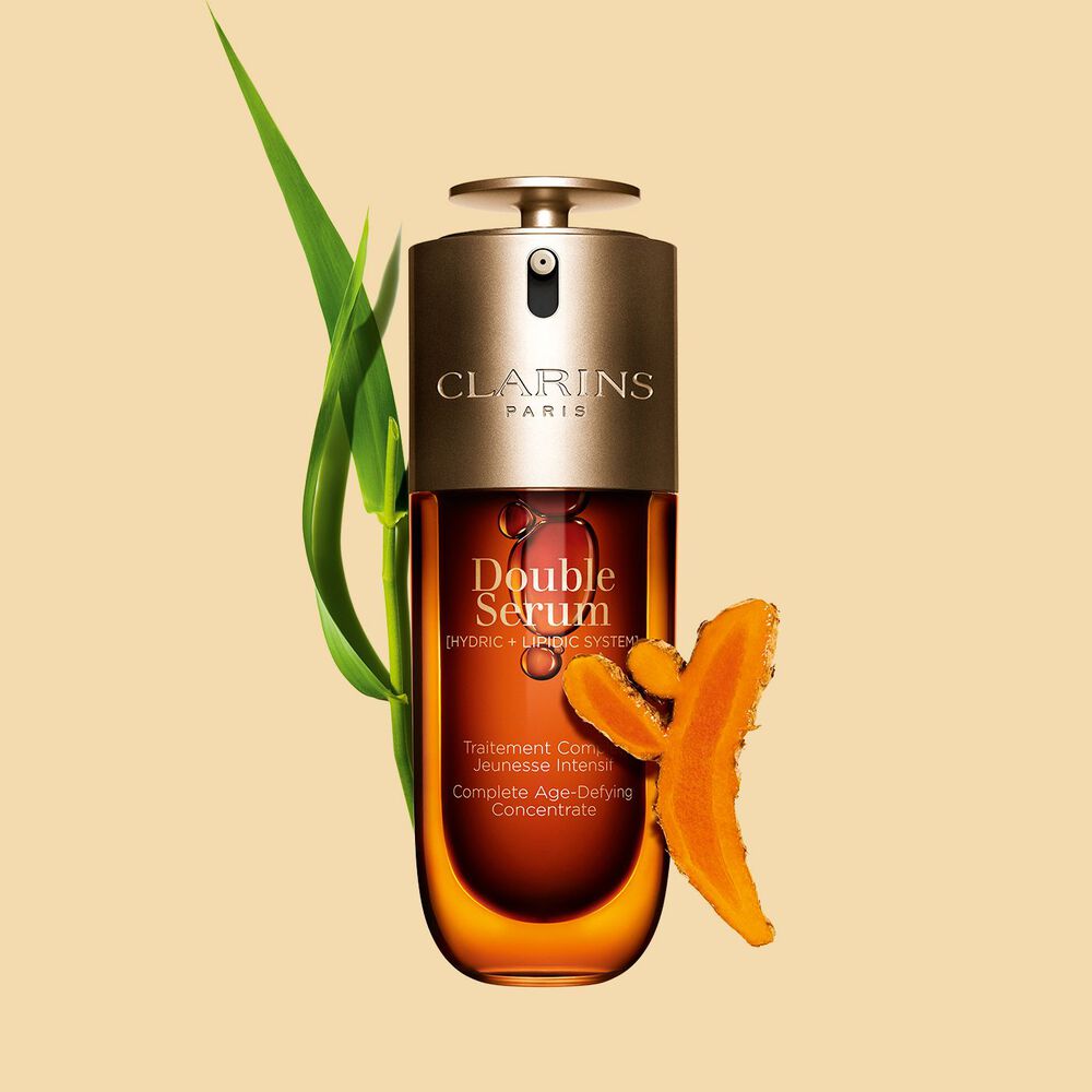 Foto de Clarins Double Serum junto a sus ingredientes, entre ellos la cúrcuma, sobre fondo dorado