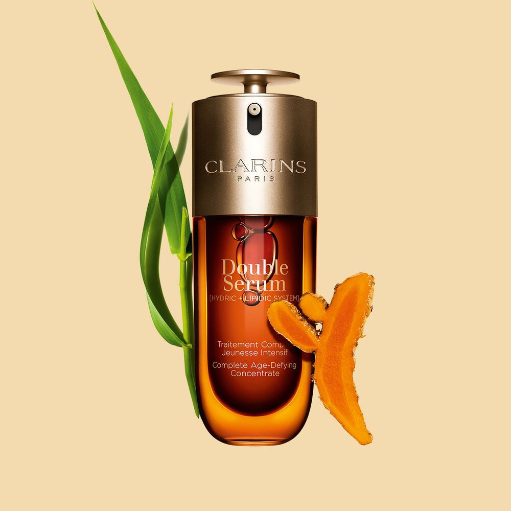 Foto de Clarins Double Serum junto a sus ingredientes, entre ellos la cúrcuma, sobre fondo dorado